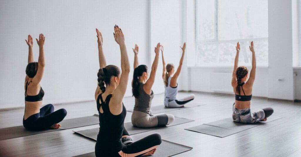 A group of women practicing yoga in an empty room.